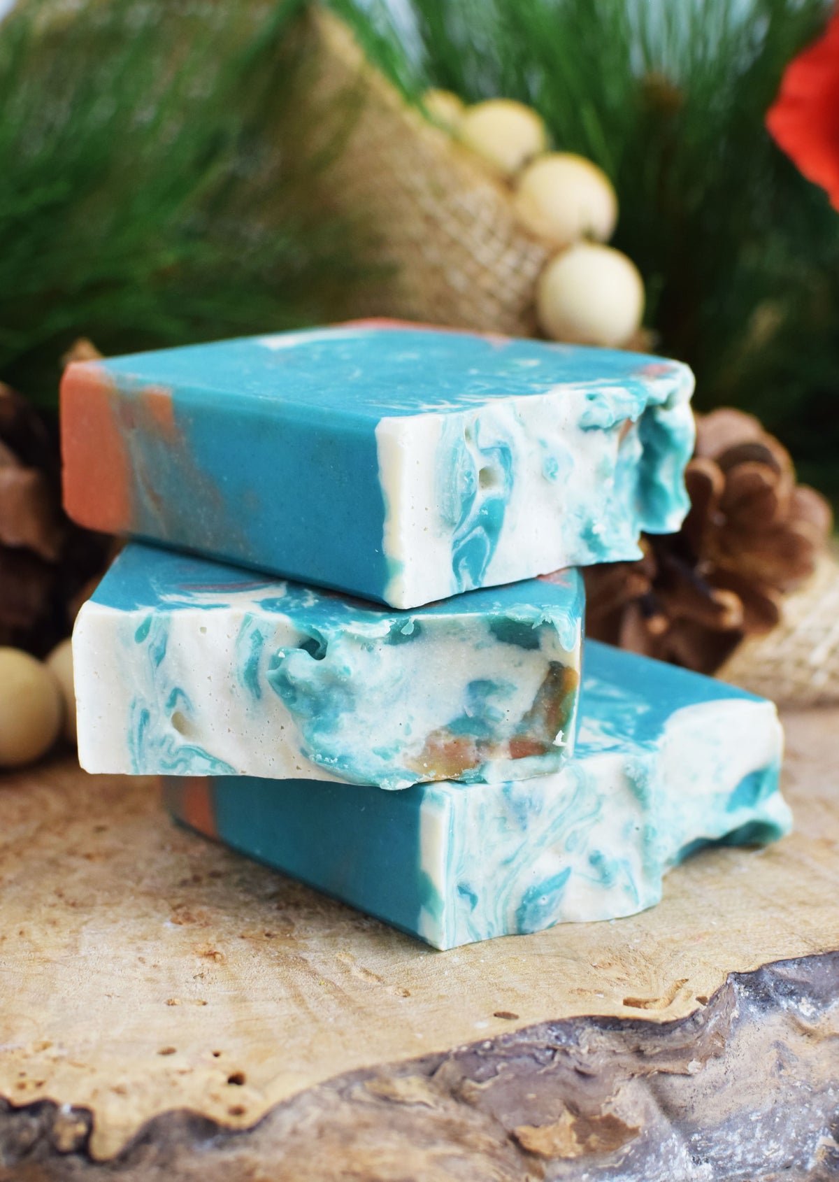 Stack of blue and green marbled soap bars on a wooden surface with a natural background.