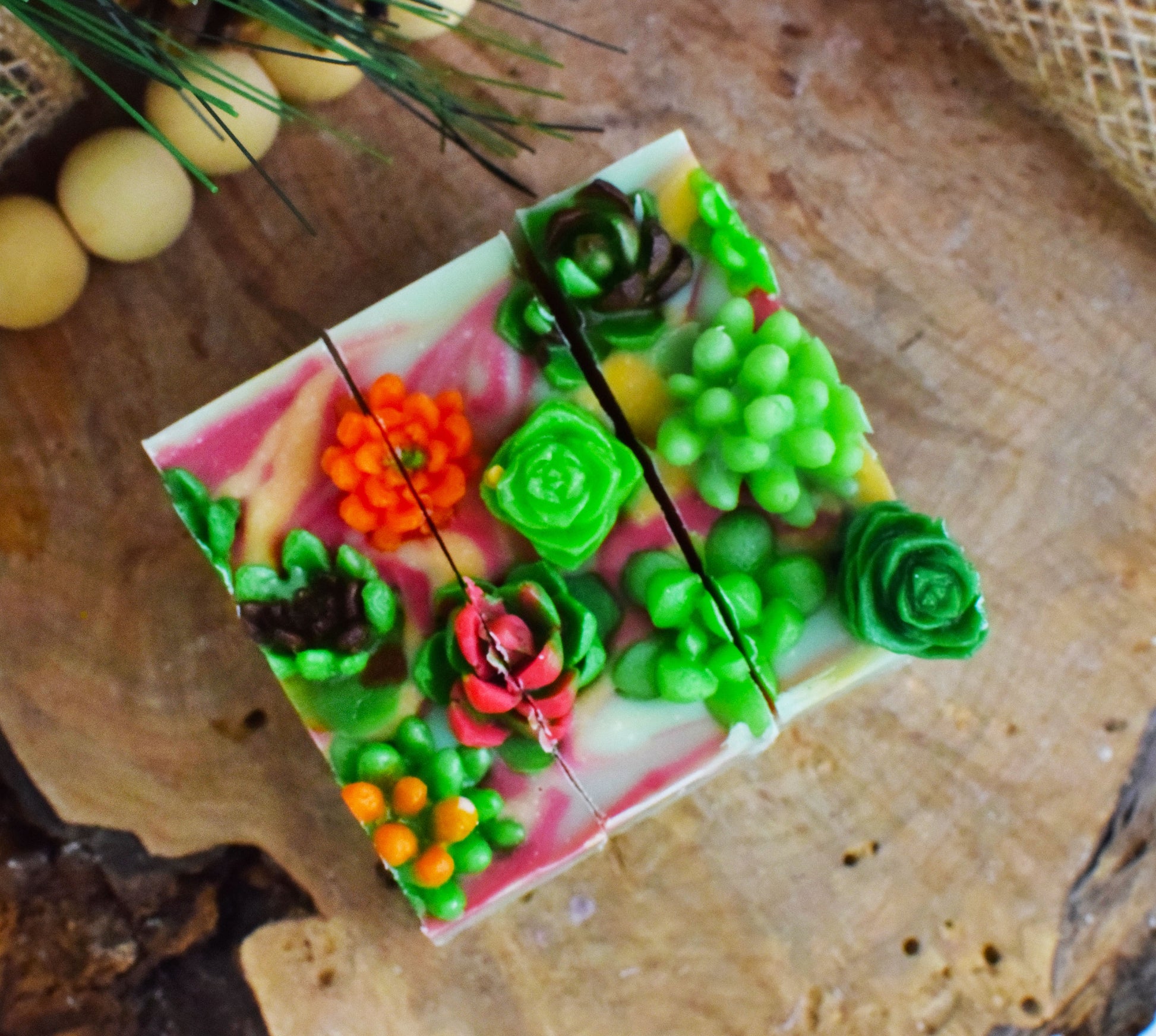 Decorative soap with succulent designs on a wooden surface