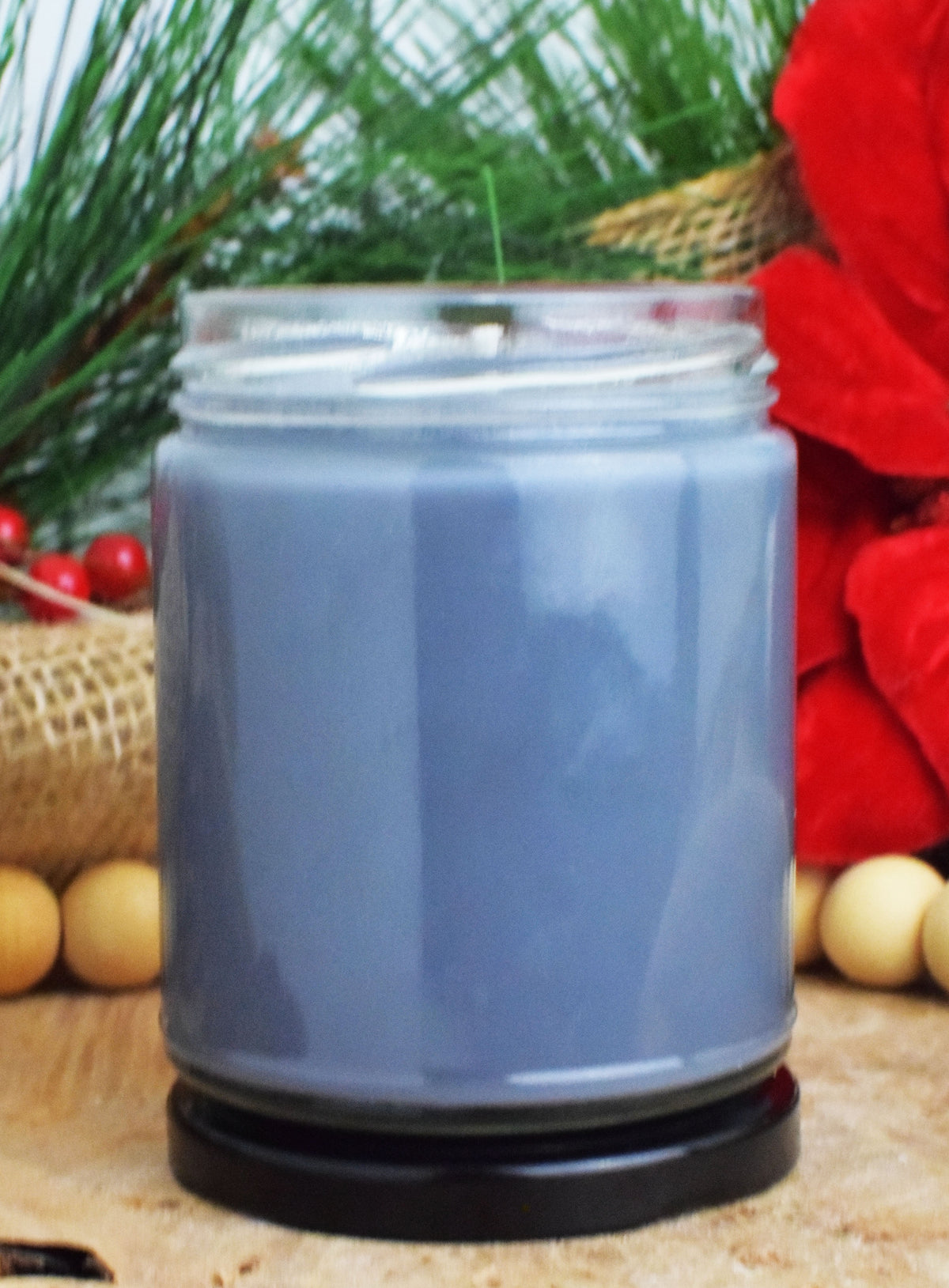 Gray candle in a glass jar with a natural background